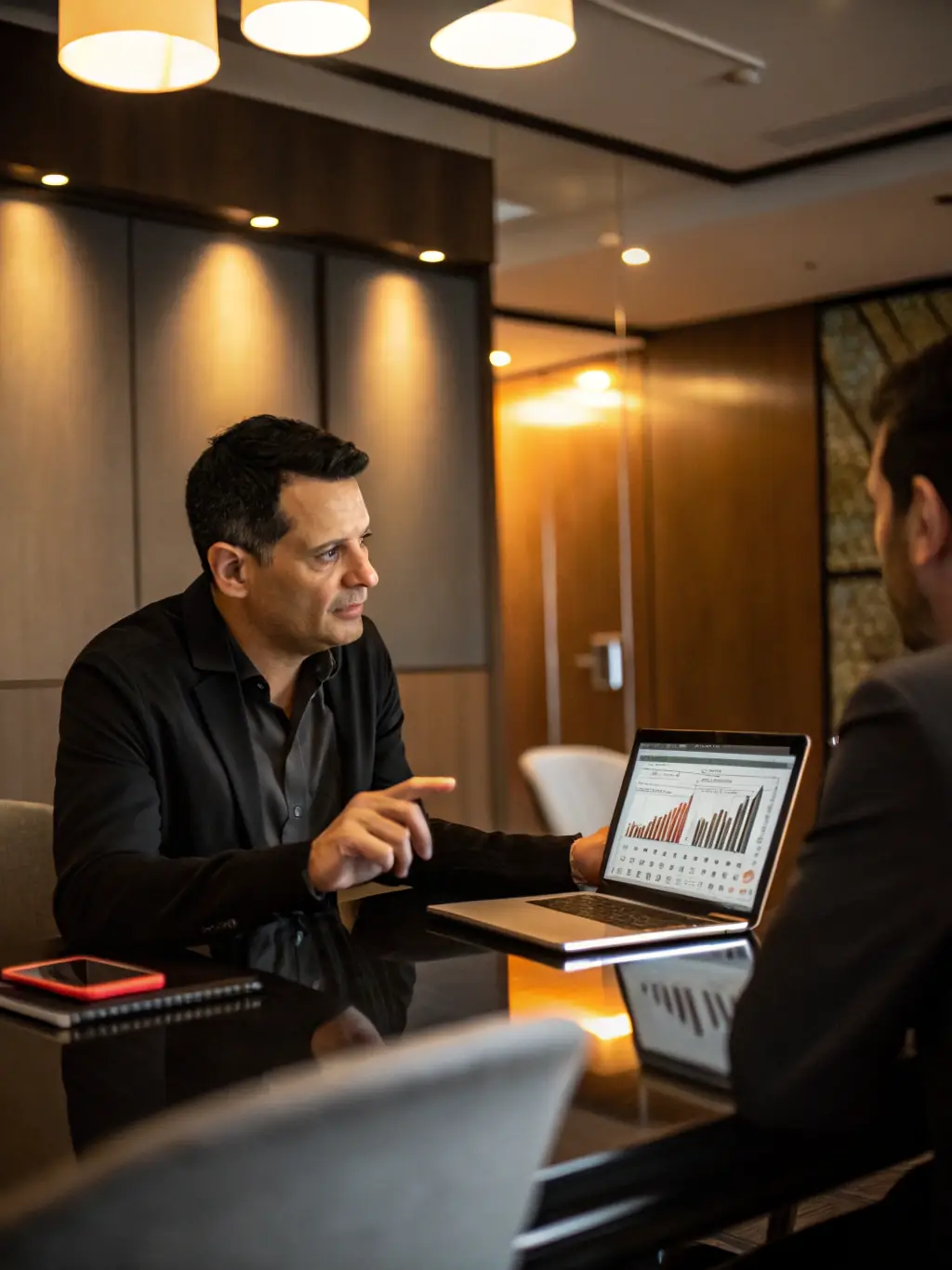 A consultant working with a client on a digital transformation strategy, using a tablet to review data and charts in a modern office setting.